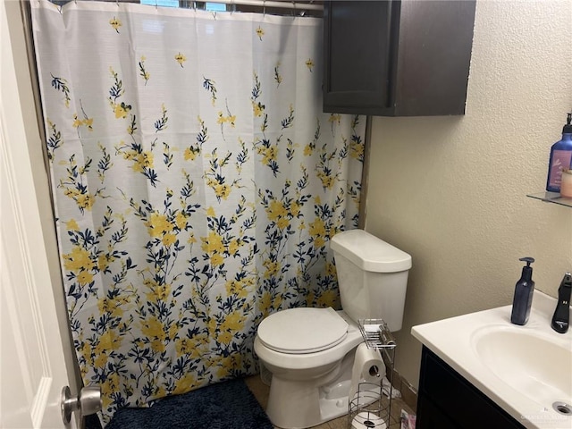 bathroom featuring a shower with curtain, vanity, and toilet