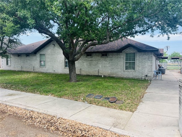 view of side of property featuring a lawn and cooling unit