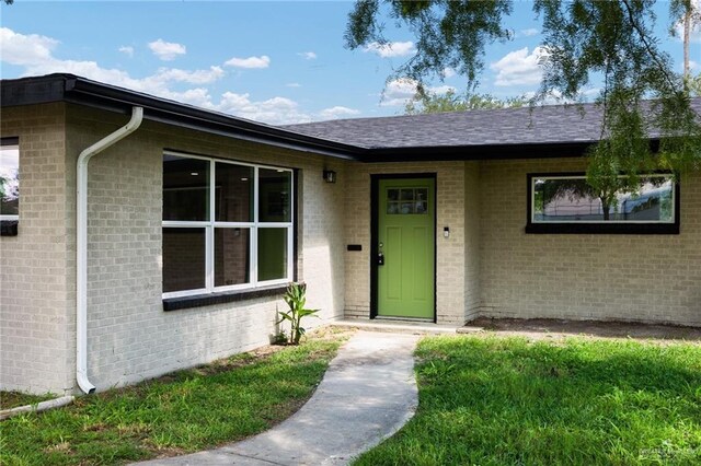 doorway to property with a lawn