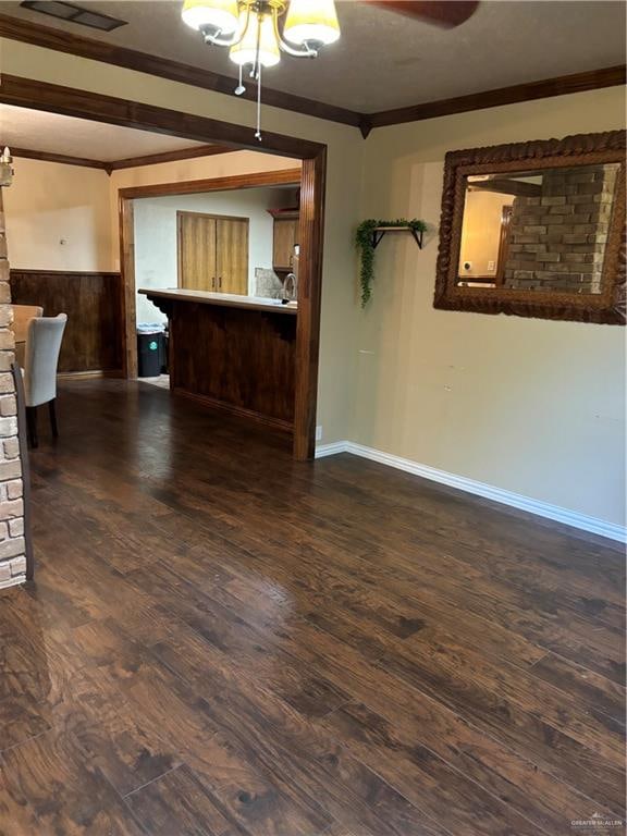 unfurnished living room with dark hardwood / wood-style flooring and ornamental molding