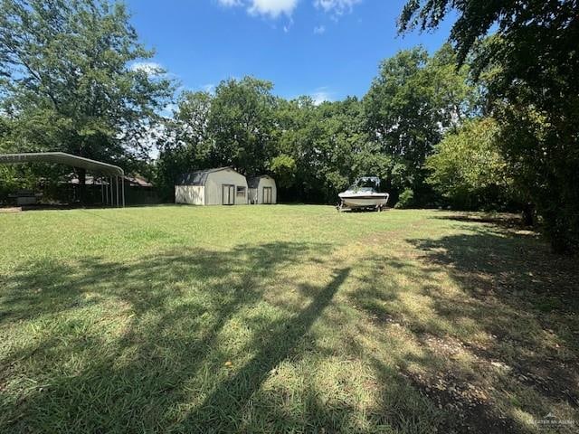 view of yard featuring a storage unit and a carport