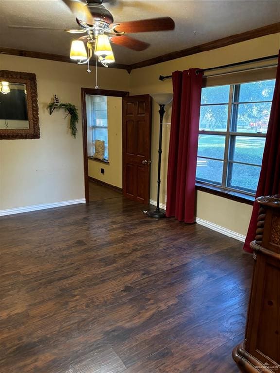 spare room with crown molding, ceiling fan, and dark wood-type flooring