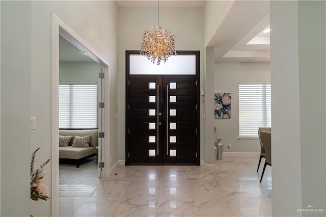 entrance foyer featuring plenty of natural light and a chandelier