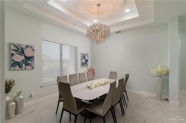 dining room featuring a tray ceiling and a notable chandelier