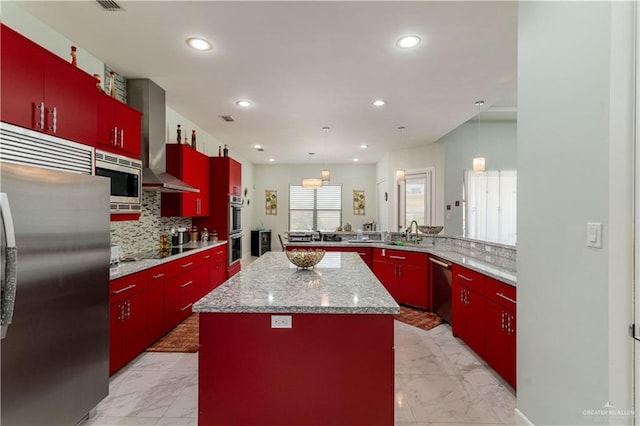 kitchen featuring pendant lighting, a center island, stainless steel appliances, and tasteful backsplash