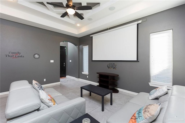 cinema featuring a ceiling fan, arched walkways, baseboards, and light tile patterned floors