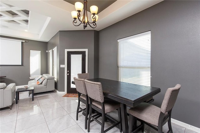dining room with baseboards, a chandelier, a tray ceiling, and light tile patterned flooring