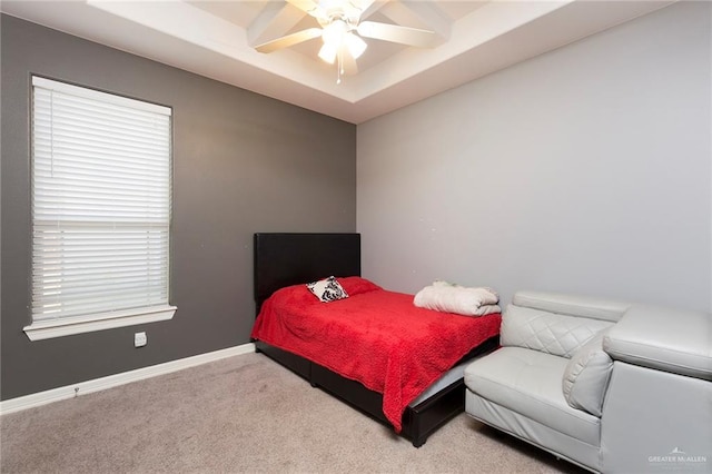 bedroom featuring carpet floors, baseboards, a raised ceiling, and a ceiling fan