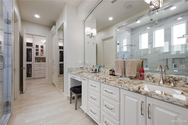 bathroom with a spacious closet, recessed lighting, a sink, a stall shower, and double vanity