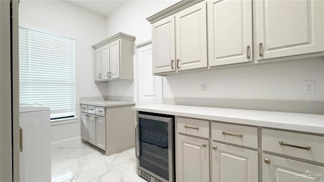 kitchen with beverage cooler and gray cabinetry