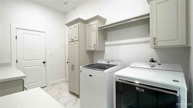 clothes washing area featuring cabinets and washing machine and clothes dryer