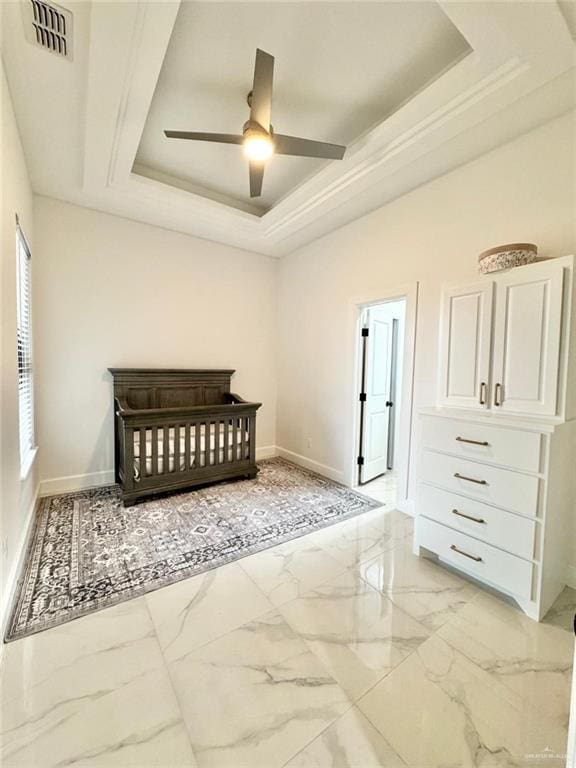 bedroom featuring a raised ceiling and ceiling fan