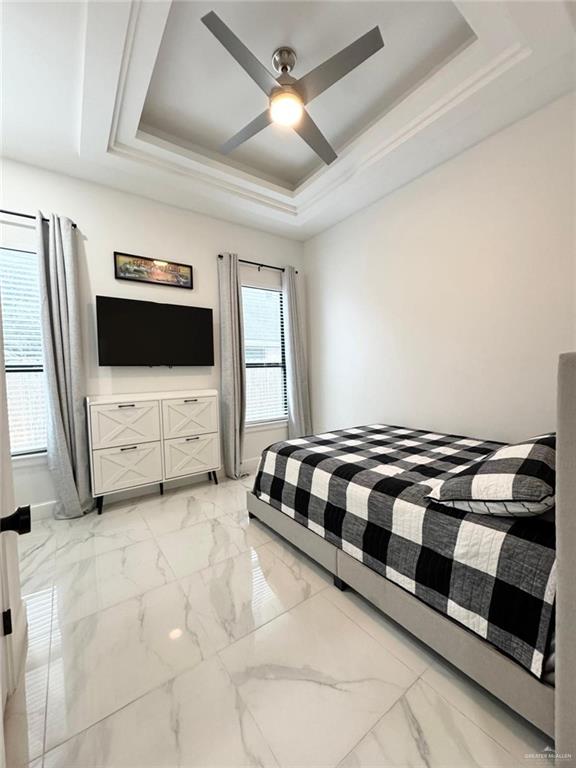 bedroom with a tray ceiling and ceiling fan