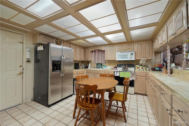 kitchen featuring white appliances, light brown cabinetry, decorative backsplash, and light tile patterned floors