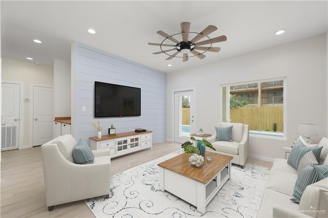 living room with ceiling fan and light wood-type flooring