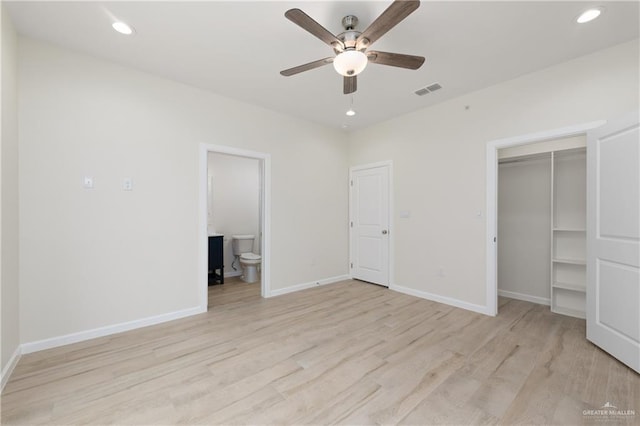 unfurnished bedroom featuring ensuite bath, a closet, ceiling fan, and light wood-type flooring