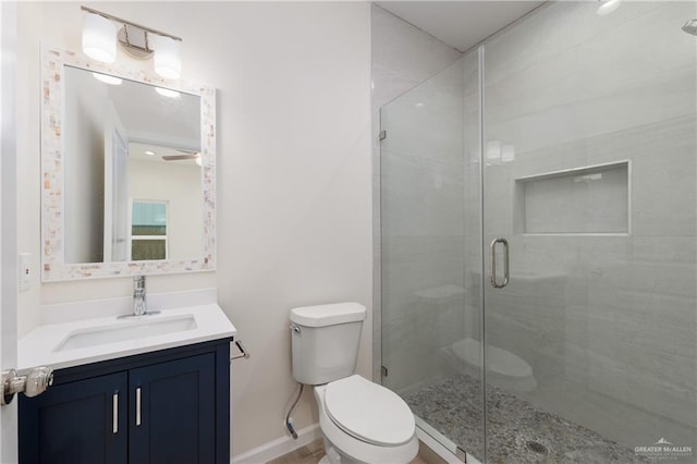 bathroom featuring vanity, toilet, and a shower with door