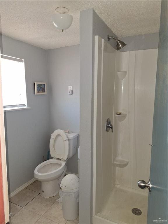 2044 Balboa Ave, Mcallen, TX 78503 - bathroom featuring a textured ceiling, a stall shower, tile patterned floors, toilet, and baseboards