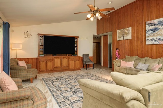 26086 Rabb Rd, La Feria, TX 78559 - living area featuring wood walls, lofted ceiling, light marble finish flooring, a ceiling fan, and a wainscoted wall