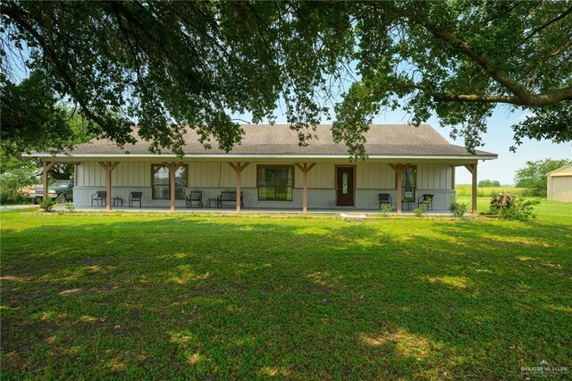 26086 Rabb Rd, La Feria, TX 78559 - back of house featuring board and batten siding, a yard, a patio, and roof with shingles