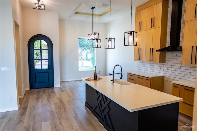 800 W Ruisenor Ave, Pharr, TX 78577 - kitchen with wall chimney exhaust hood, light wood finished floors, an island with sink, tasteful backsplash, and pendant lighting