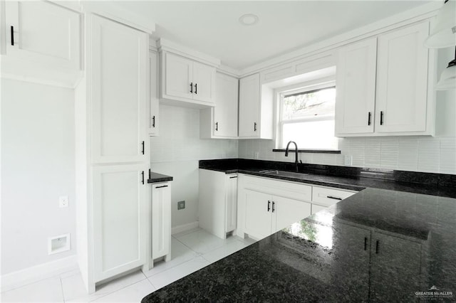 kitchen with white cabinets, backsplash, and dark stone counters