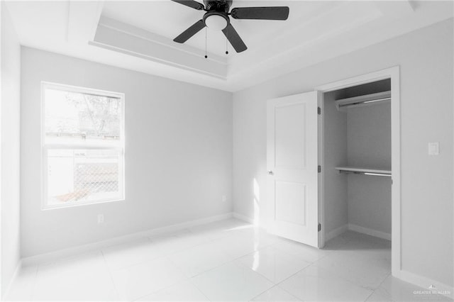 unfurnished bedroom with a closet, a raised ceiling, and ceiling fan