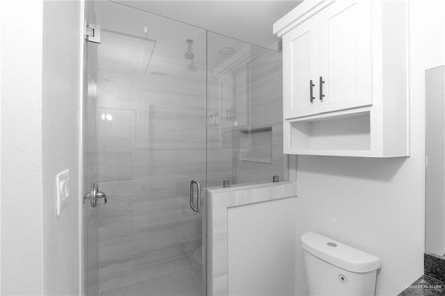 bathroom featuring toilet and walk in shower