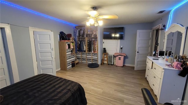 bedroom with ceiling fan, a closet, and light hardwood / wood-style flooring