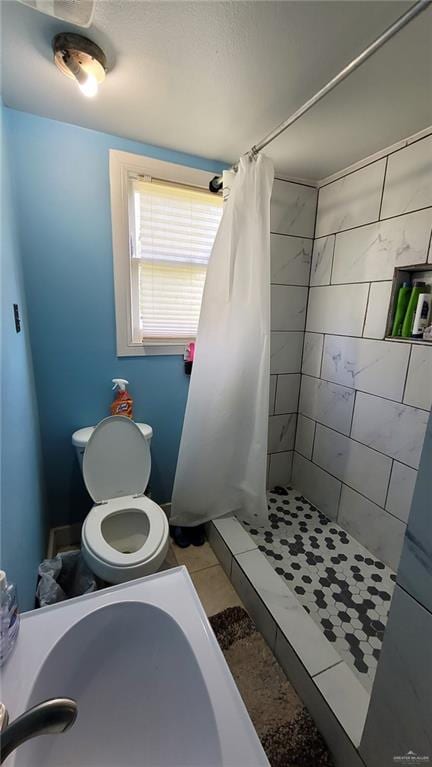 bathroom featuring tile patterned flooring, curtained shower, and toilet