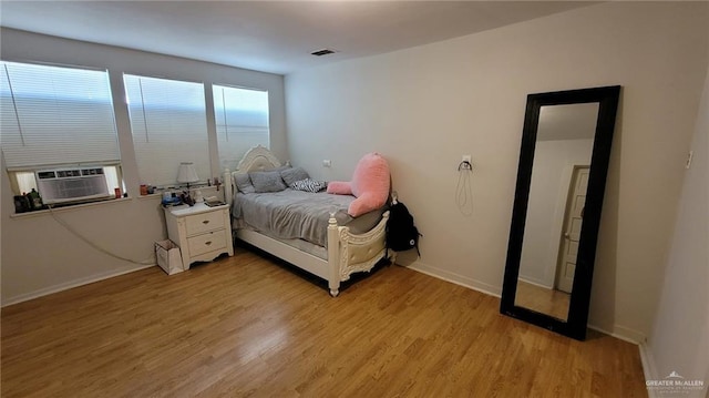 bedroom featuring cooling unit and light wood-type flooring