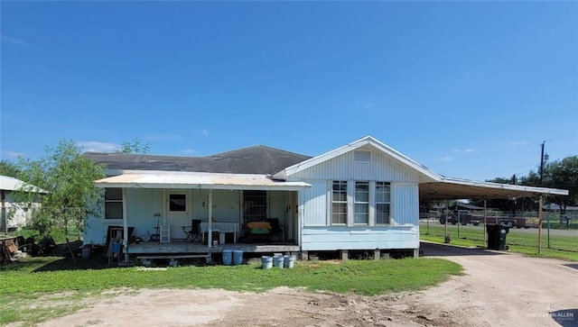 back of property with a carport and covered porch