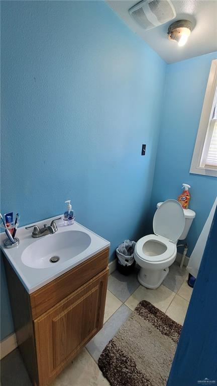 bathroom featuring vanity, toilet, and tile patterned flooring