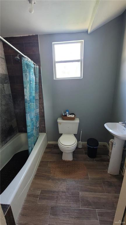 full bathroom with shower / bathtub combination with curtain, sink, and toilet