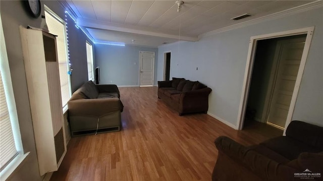 living room featuring ornamental molding, hardwood / wood-style floors, and beam ceiling