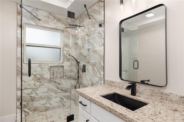 bathroom with vanity and a shower with shower door