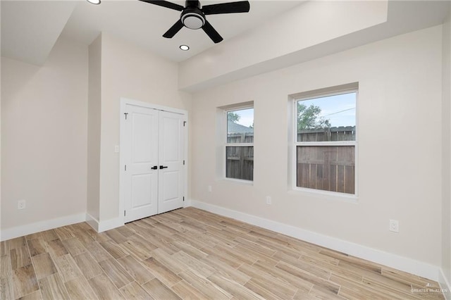 unfurnished bedroom with ceiling fan, light hardwood / wood-style floors, and a closet