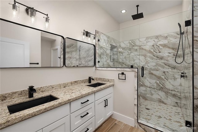 bathroom with wood-type flooring, vanity, and a shower with shower door