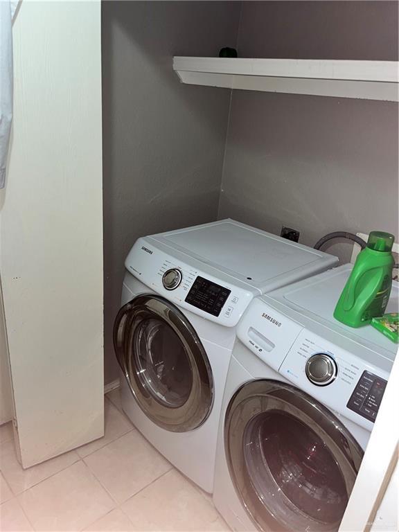 laundry room featuring washing machine and dryer, laundry area, and light tile patterned flooring