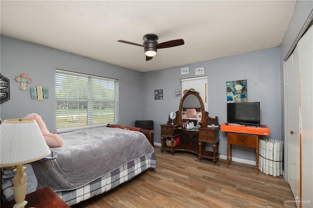 bedroom with hardwood / wood-style flooring, ceiling fan, and a closet