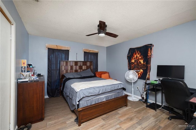 bedroom featuring ceiling fan, light hardwood / wood-style floors, and a textured ceiling