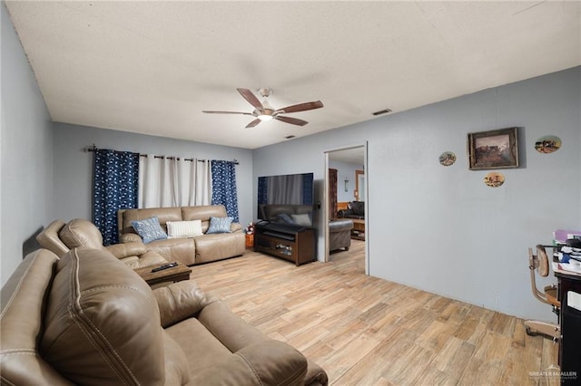 living room featuring ceiling fan and light hardwood / wood-style flooring