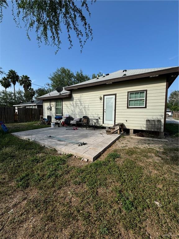 back of property with a yard and a patio