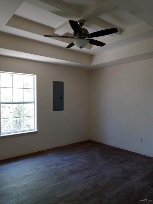 spare room with beamed ceiling, electric panel, ceiling fan, and dark wood-type flooring