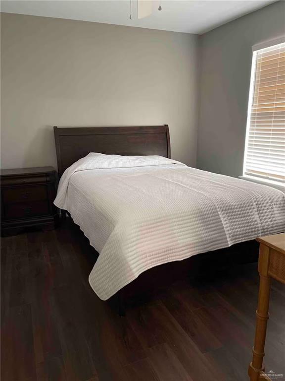 bedroom with dark wood-type flooring