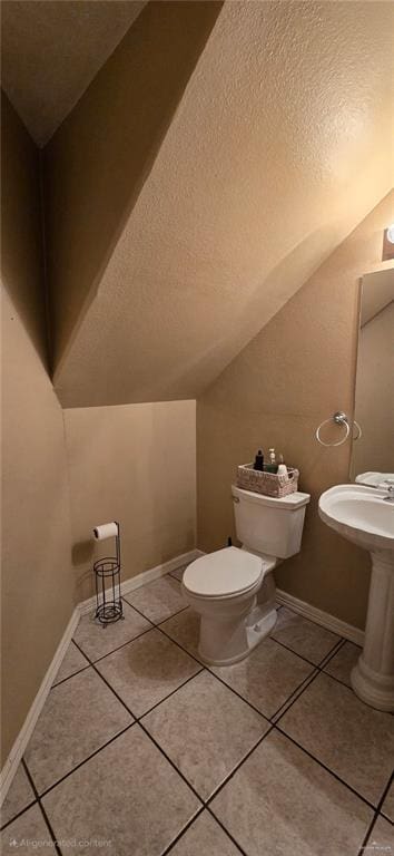 1706 Primrose Ave, Mission, TX 78572 - half bathroom featuring a textured ceiling, vaulted ceiling, tile patterned floors, toilet, and baseboards
