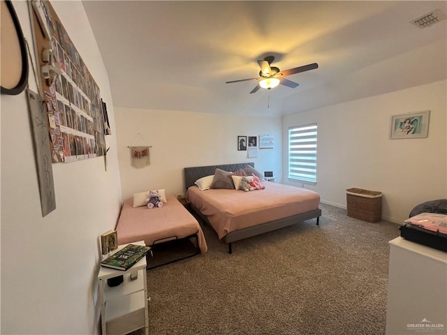 carpeted bedroom featuring baseboards, a ceiling fan, and visible vents