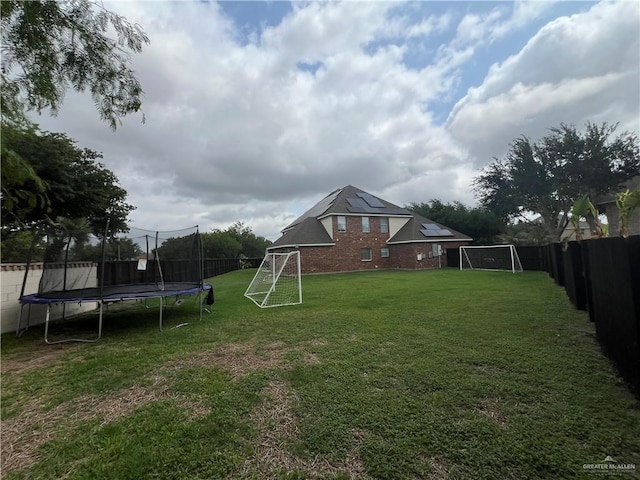 view of yard with a fenced backyard and a trampoline