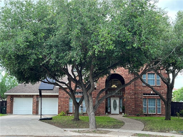 view of front of property with brick siding, roof mounted solar panels, a garage, and concrete driveway