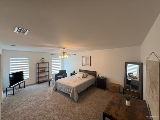 bedroom featuring carpet floors, visible vents, ceiling fan, and multiple windows